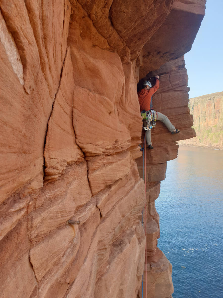 Man climbing Old man of hoy sea stack | Higher Climbing – Wales mountain climbing courses and guided adventures for beginners and experienced climbers